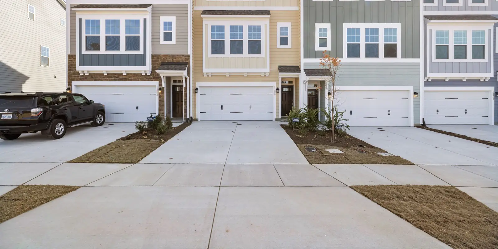 Four townhouse driveway aprons and the sidewalk across them, boundary drawn.