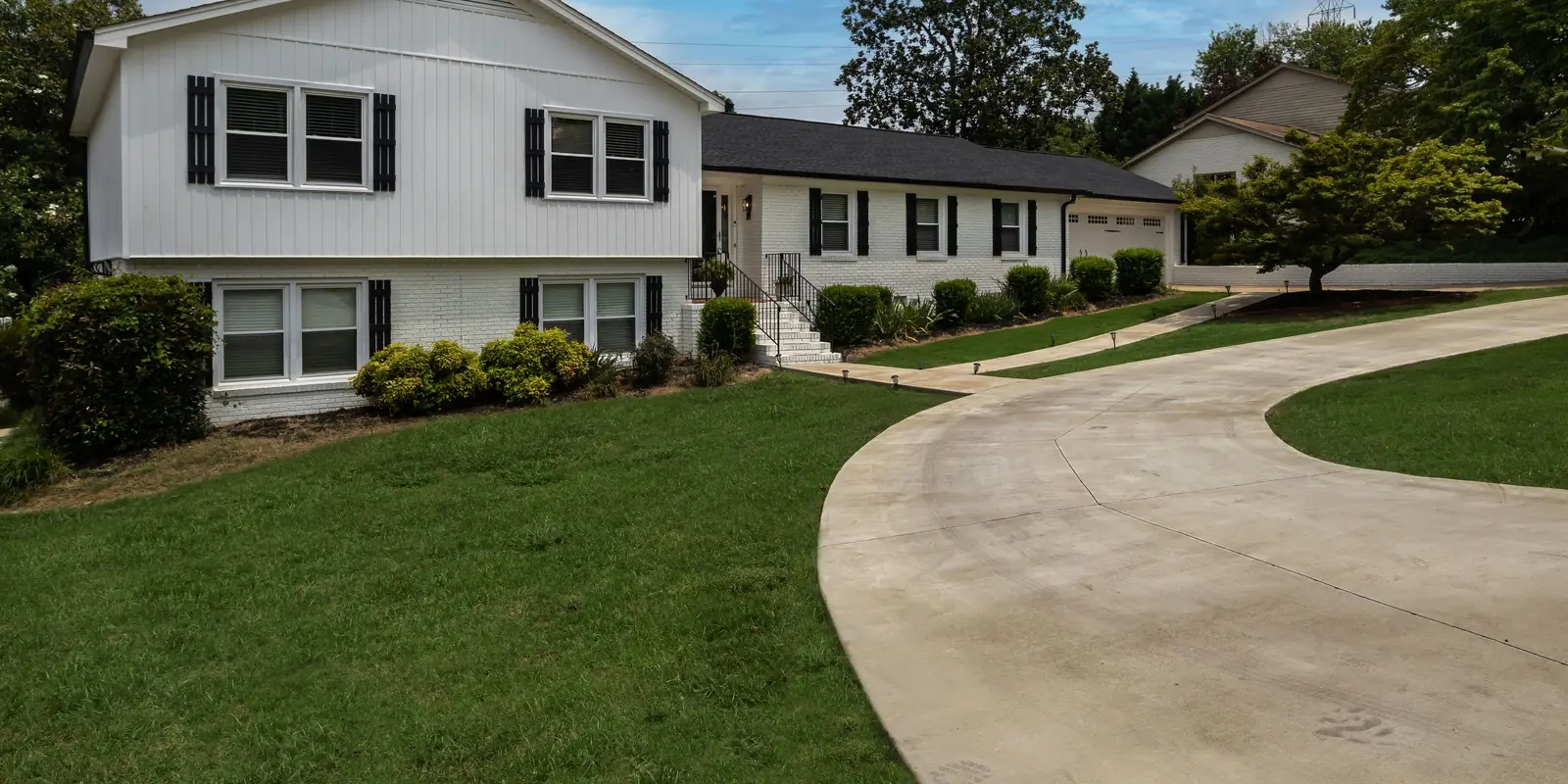 A concrete driveway curving around a lawn, its boundary drawn.