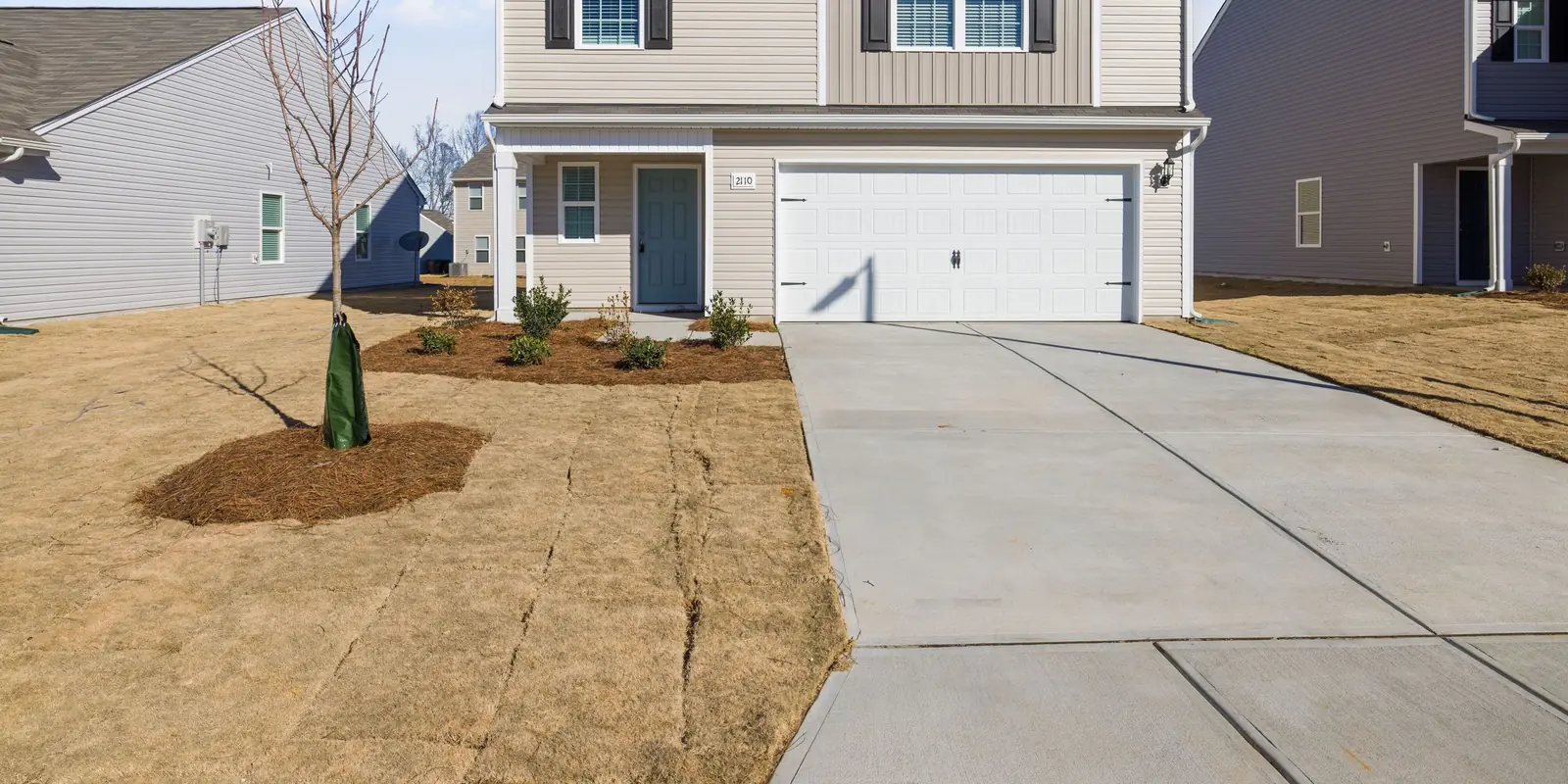 A straight concrete driveway and the walk to the front door, boundary drawn.