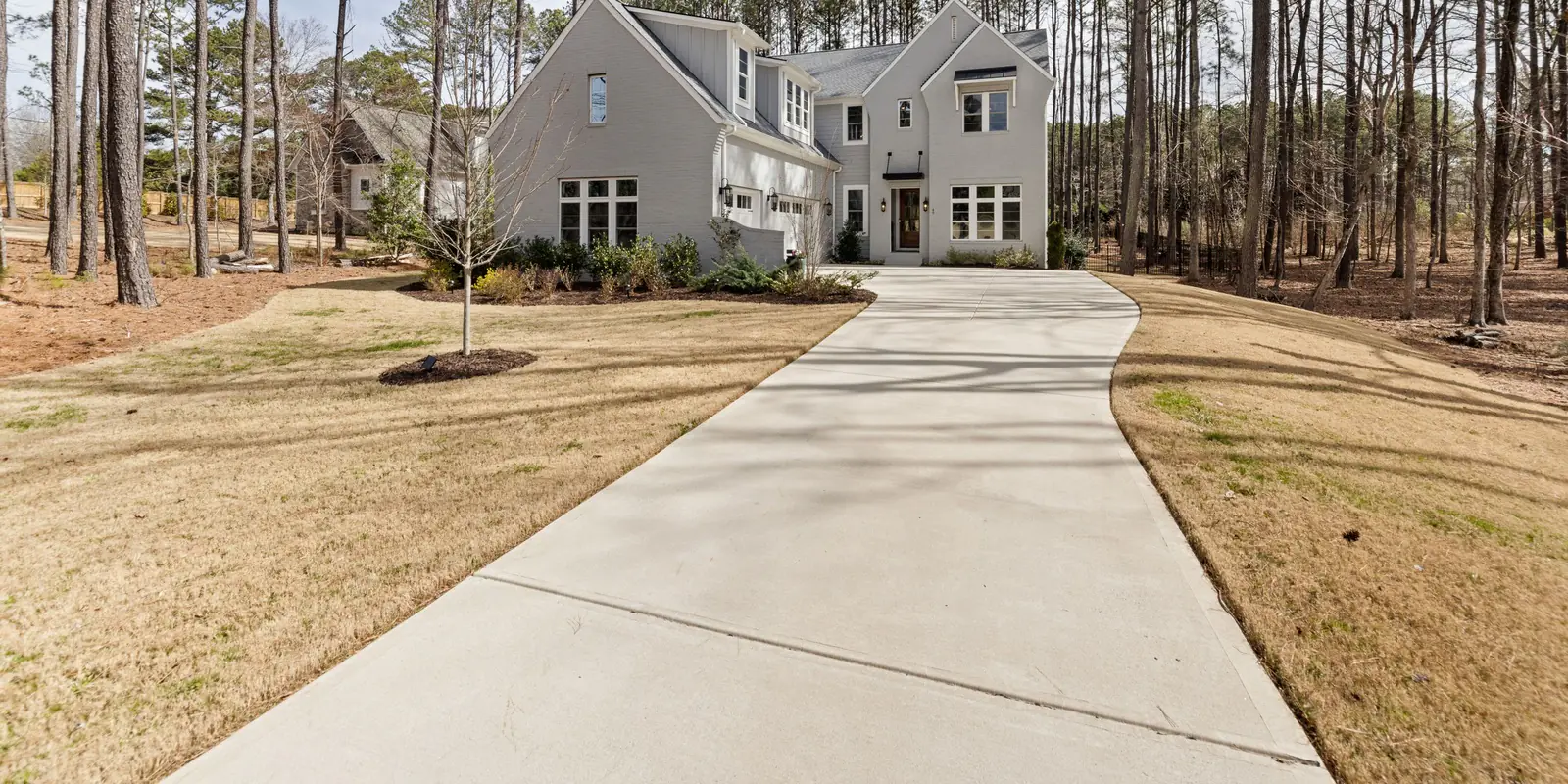 A long concrete driveway running up through pine woods to a house, its boundary drawn.
