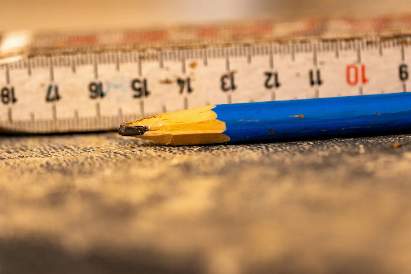 A folding rule and a carpenter's pencil on a work surface.