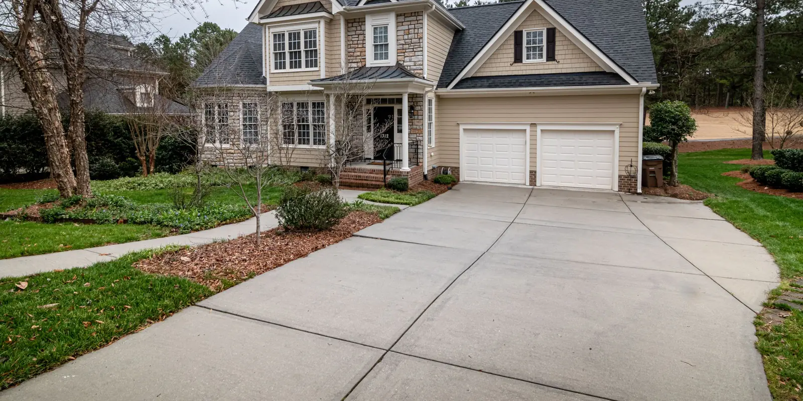 A wide concrete driveway apron in front of a two-car garage, its boundary drawn.